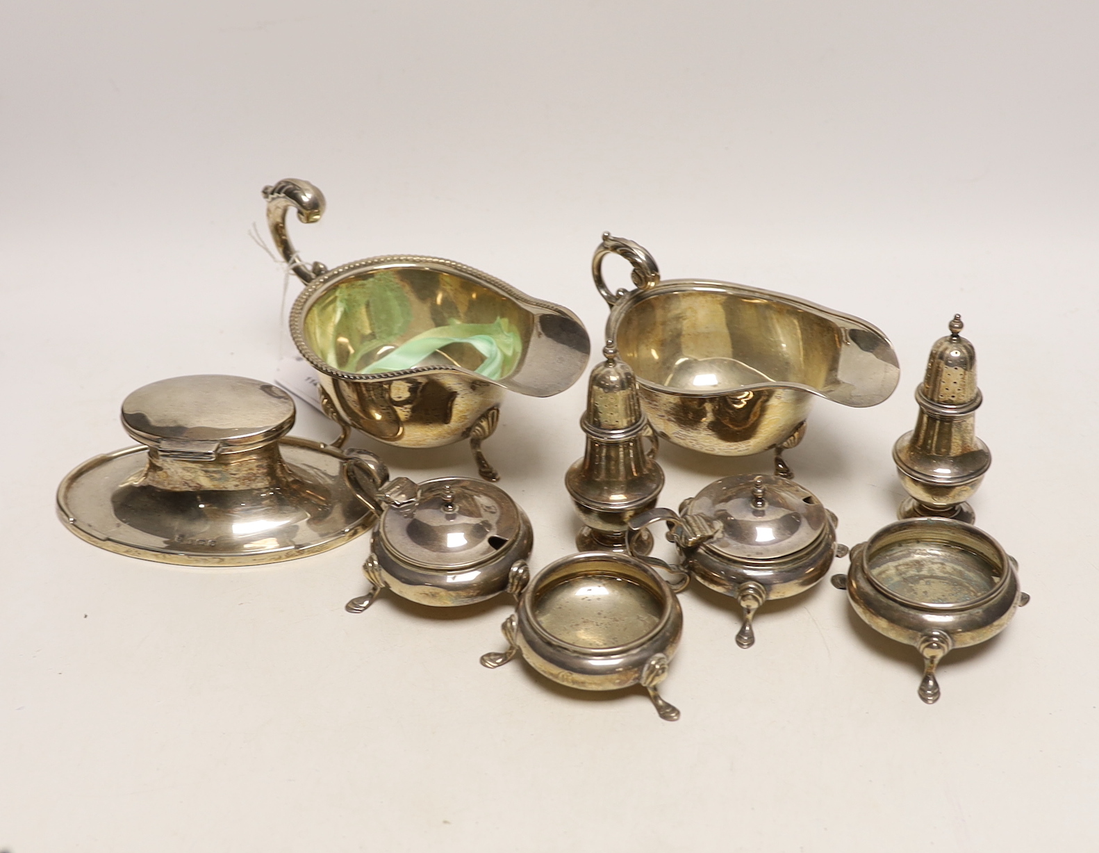 A small selection of silver items to include two sauceboats, a pair of cauldron salts, a further pair of lidded cauldron salts, together with a pair of pots and an inkwell.